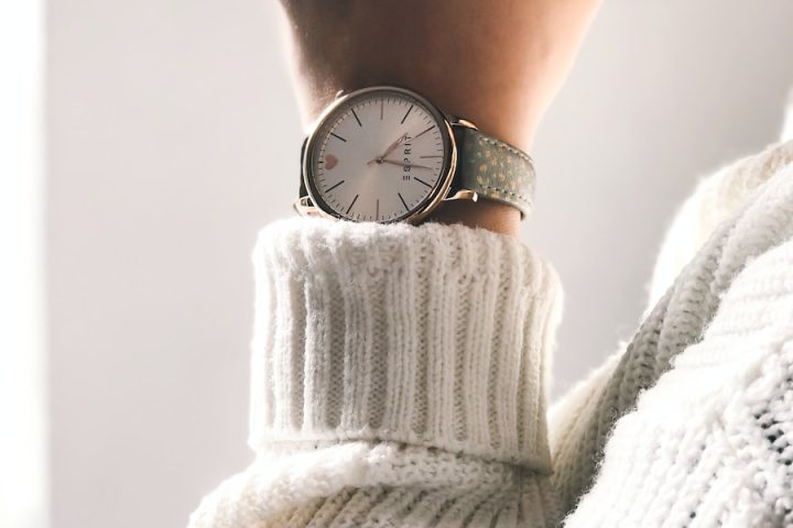 person wearing round silver-colored analog watch