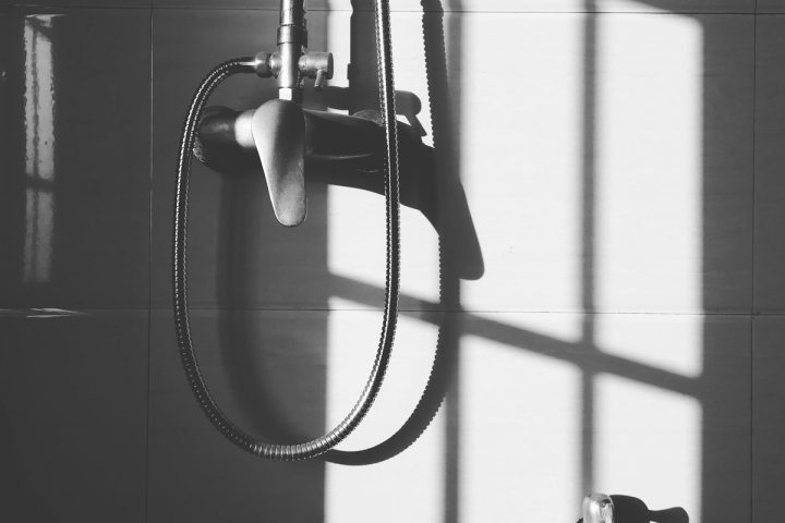 gray stainless steel shower head hanged on wall during daytime