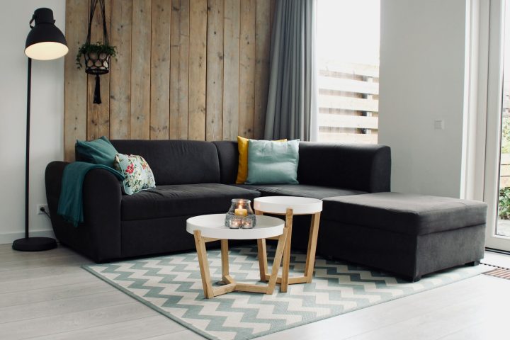 light candle on round white coffee table and sectional sofa