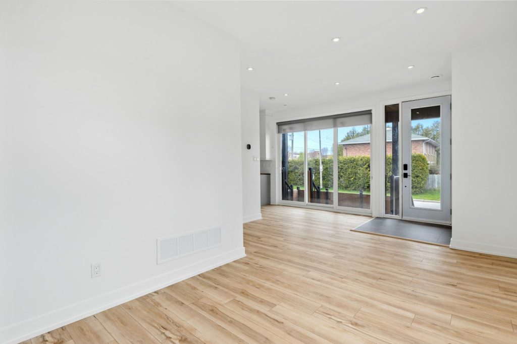 a room with a wood floor and windows